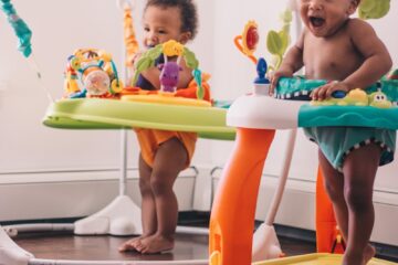 2 children playing on green and blue plastic slide