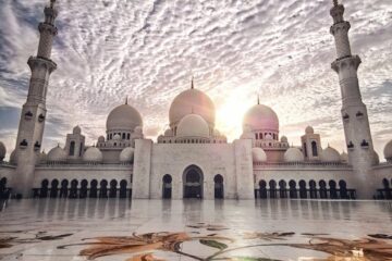 Sunset at the Sheikh Zayed Mosque showcasing stunning architectural beauty and cloud formations.