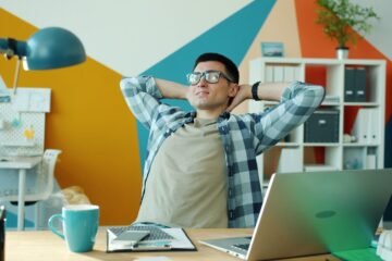 Man relaxing at desk in colorful office