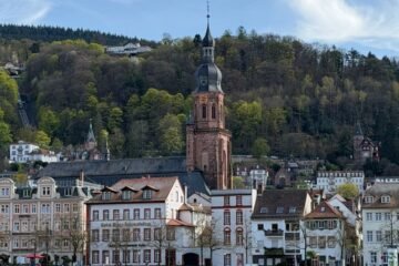 View of historic buildings and a church by the river in Heidelberg, Germany.