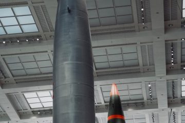 Two tall missiles with pointed tips indoors