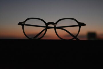 black framed eyeglasses on black surface
