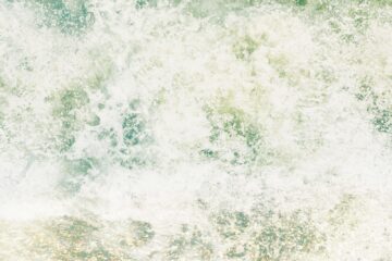 a surfboard sitting on top of a wave in the ocean