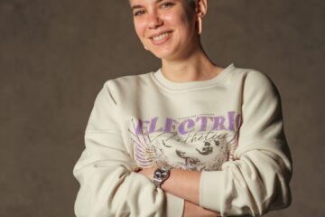 a woman with her arms crossed posing for a picture