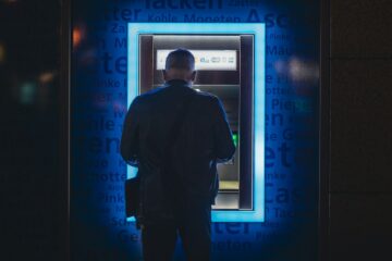 a man standing in front of an atm machine