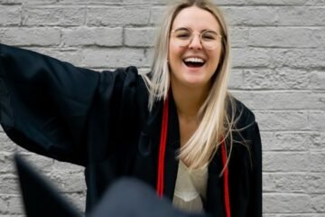 woman in black academic gown smiling