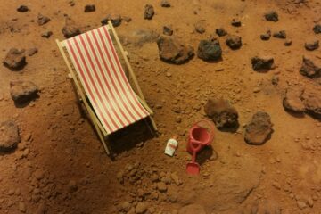 red and white striped folding bed on brown sand