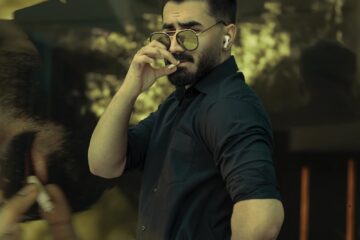 man in black button up shirt holding black dslr camera