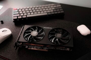 A desk with a keyboard, mouse, and other electronics