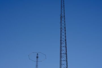 black steel electric post under blue sky during daytime