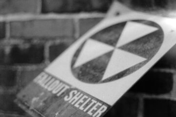 a black and white photo of a sign on a brick wall