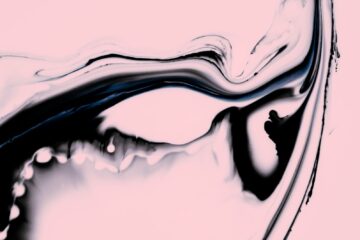 a close up of a liquid substance on a pink background
