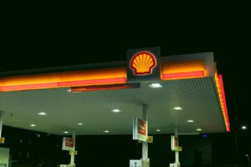 a shell gas station at night with a lit up sign