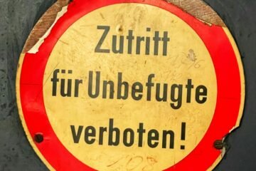 a red and yellow sign that reads zuritt fur unbefuge ve