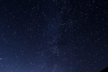 silhouette of man looking at milky way