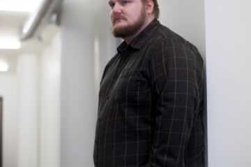 man leaning on wall