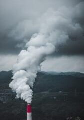 a red and white pipe emits smoke into the sky