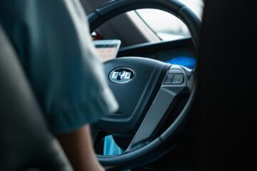 person in blue shirt driving car