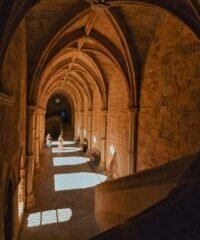 A long hallway in a building with stone walls and arches