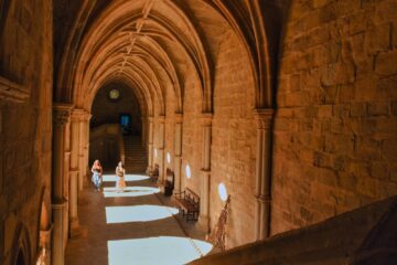 A long hallway in a building with stone walls and arches