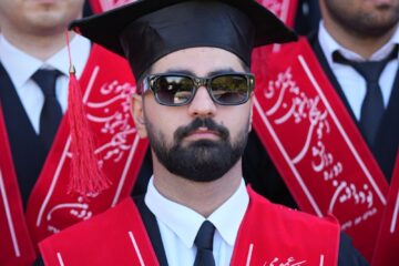 Graduates in caps and gowns at a ceremony.