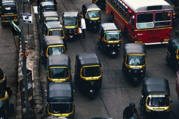 black-and-yellow auto rickshaw on road