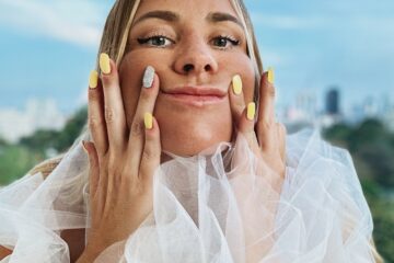 a woman with yellow nails and a white dress