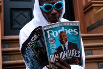 man in white long sleeve shirt holding magazine