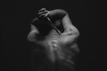 man holding gray dagger