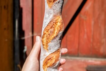 a person holding a piece of bread in their hand